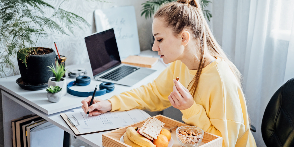 a professional woman eating healthy snacks while working